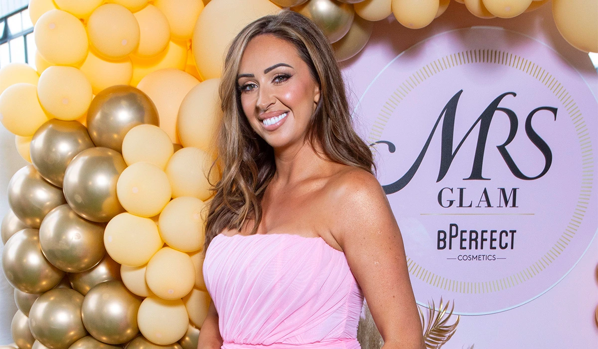 Michelle Regazzoli Stone smiling at an MRS Glam event backdrop
