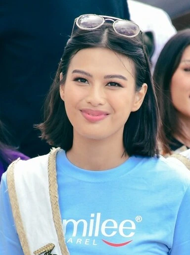 Michelle Dee smiling outdoors in a blue shirt