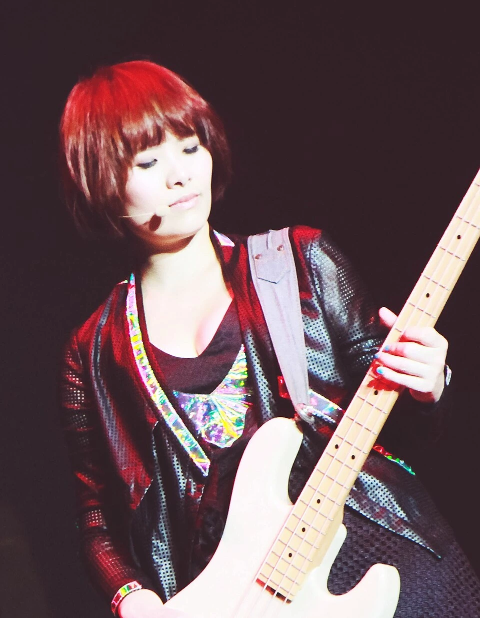 Michelle Chia Yun Yi performing on stage with a bass guitar