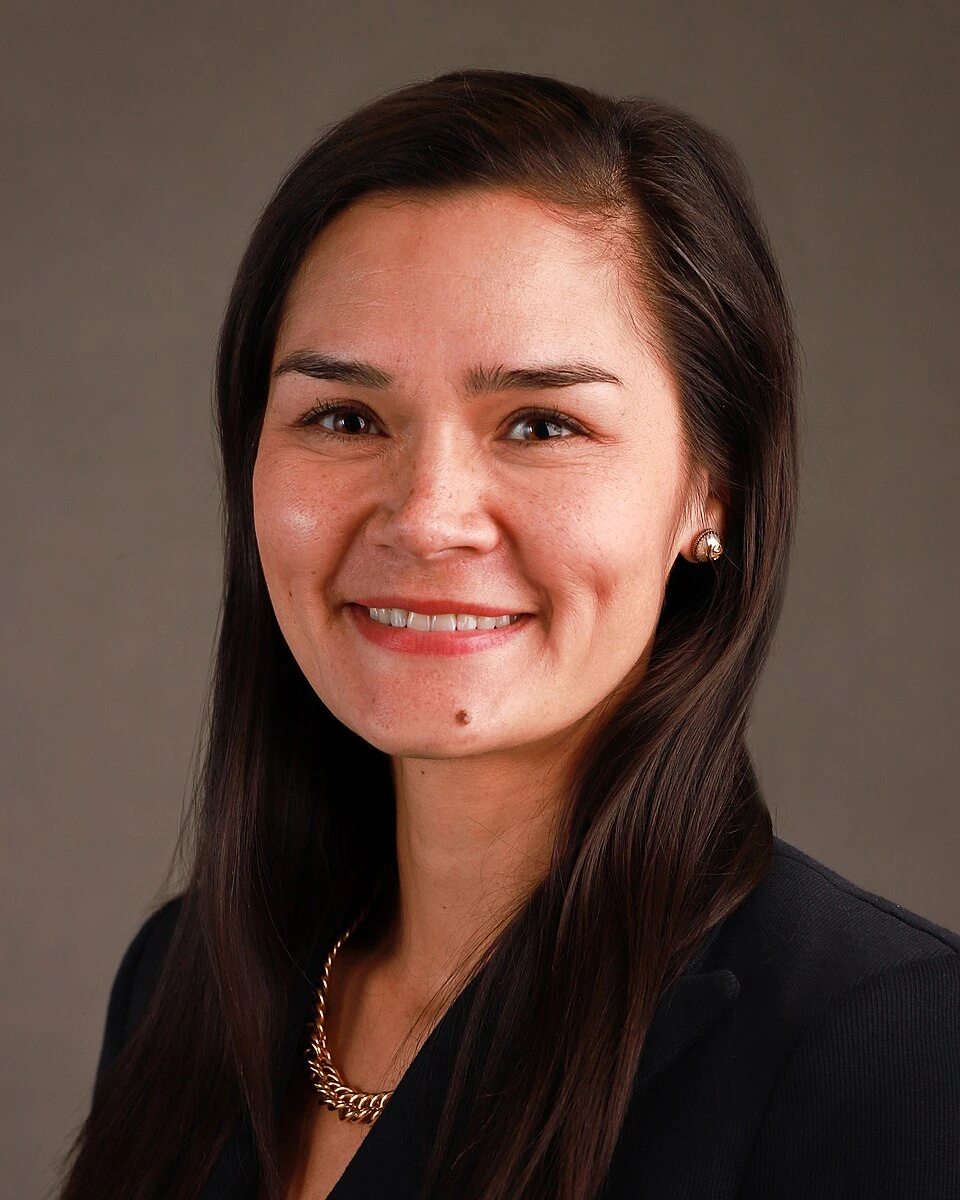 Portrait of Michelle Giuda smiling against a neutral background