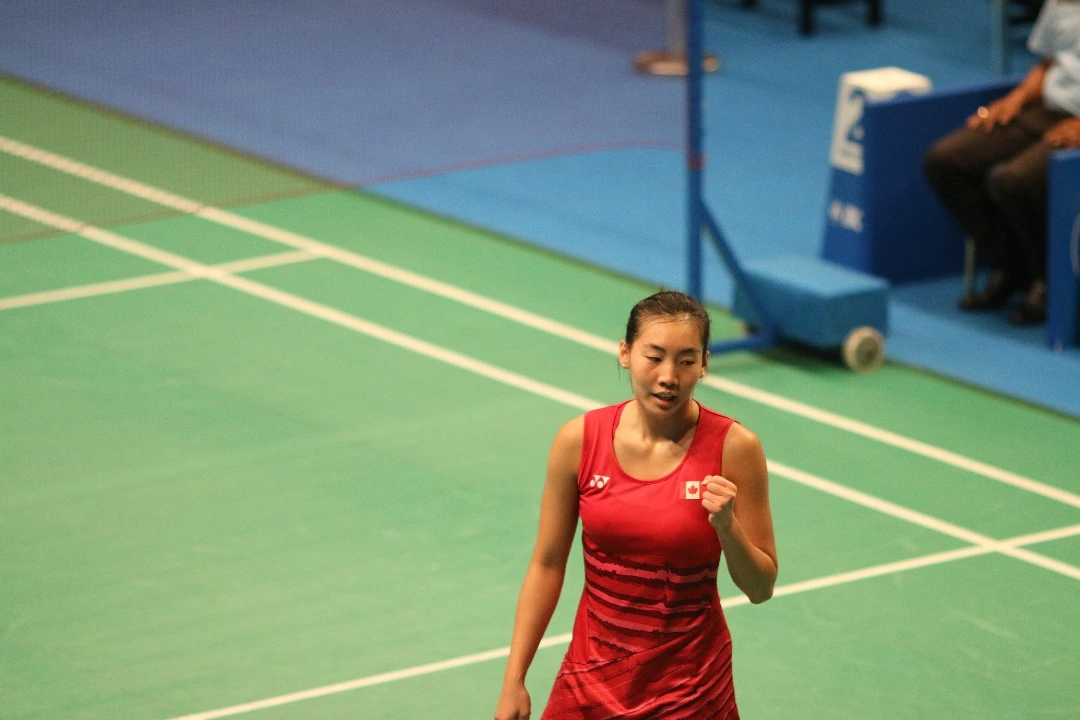 Michelle Li in a badminton match wearing a red Canadian jersey on court